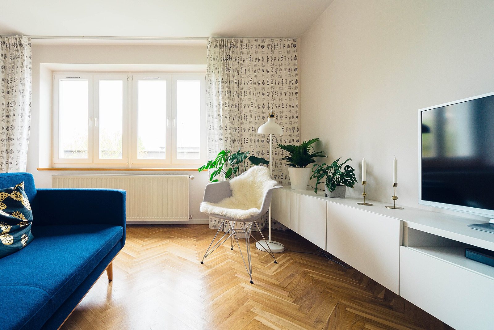 Jasny salon z lampą stojącą przy fotelu